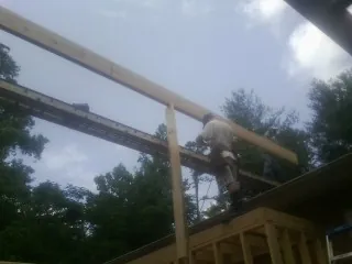 Carpenter setting a ridge beam over a new addition frame — Ice Dam Removal by Roofing Brothers in Wausau