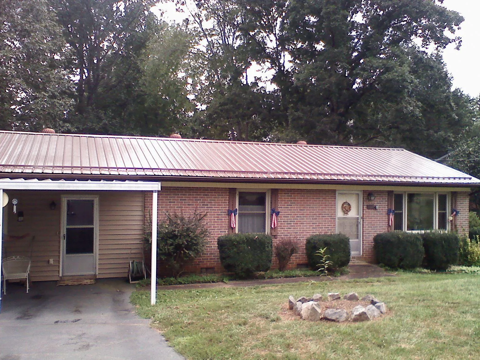 Bronze metal roof and carport on a brick ranch home — Roof Repair work by our crew in Wausau